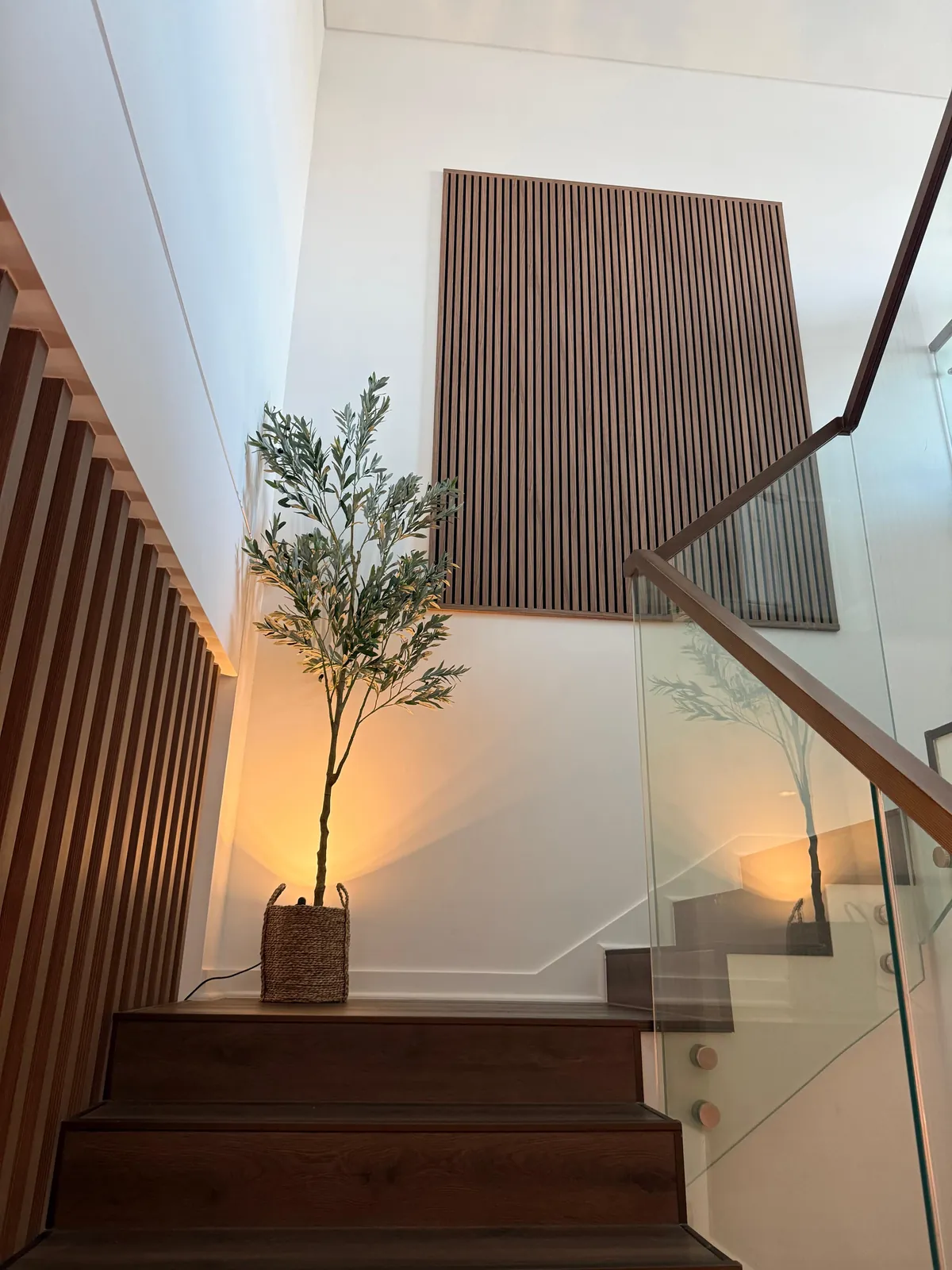 Framed slatted wall panel above a staircase, with slatted cladding and concealed lighting along the stair